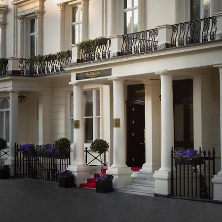 Montcalm Chilworth Townhouse, Paddington Hotel London Ngoại thất bức ảnh The photo shows an elegant building entrance with classic architectural features. It has several tall, white columns supporting a balcony adorned with ornamental railings. The entrance is flanked by decorative planters with flowers. A set of steps le