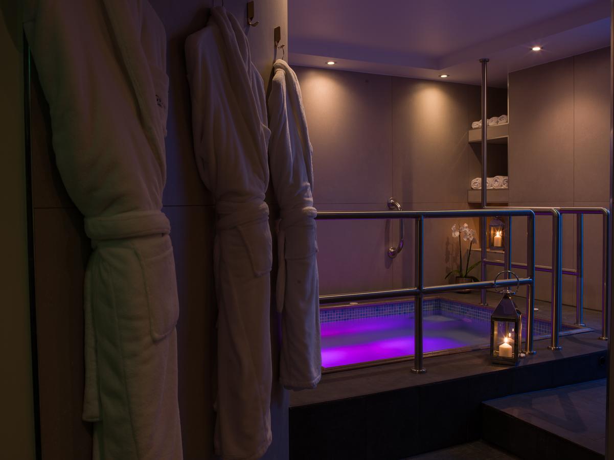 Montcalm Chilworth Townhouse, Paddington Hotel London Ngoại thất bức ảnh The photo depicts a serene spa setting. On one side, there are several plush bathrobes hanging on a rail, suggesting a relaxing atmosphere. In the background, a hot tub is visible, illuminated with soft purple lighting, enhancing the tranquil vibe. T