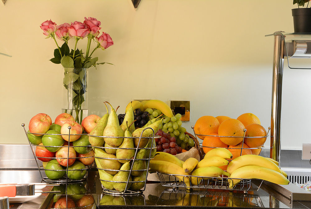 Montcalm Chilworth Townhouse, Paddington Hotel London Ngoại thất bức ảnh The photo shows a countertop arrangement with several baskets of fruit. There are green and red apples in one basket, green and yellow pears in another, and a mixture of grapes and bananas in different baskets. Additionally, there are oranges arrange